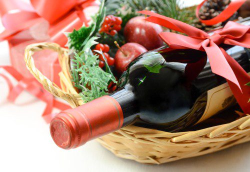 red wine bottle in a basket for Christmas party with gift box