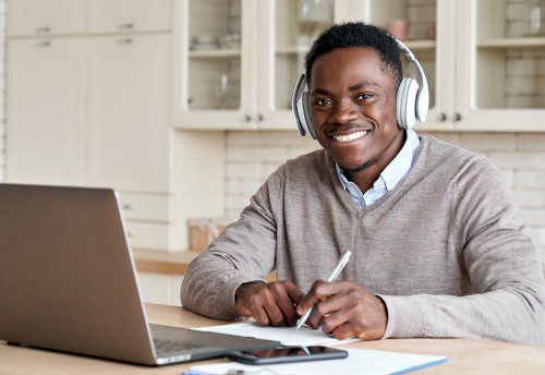 young male accountant Watching Nexia video with headphones on