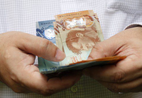 man holding New Zealand banknotes