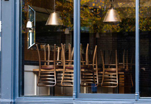 closed cafe with chairs upside down on tables