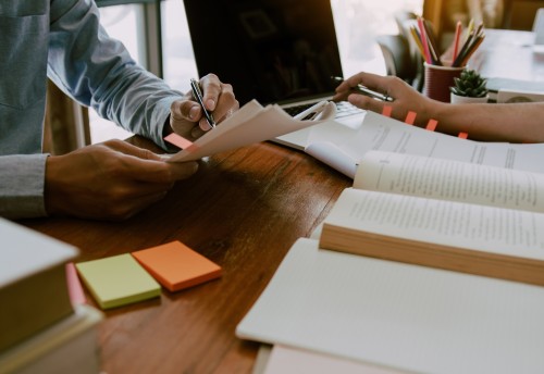 Two accountants in a meeting with books open on desk