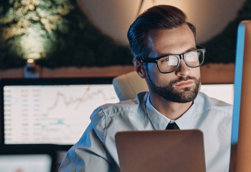 male accountant looking at graphs on computer screen in the office