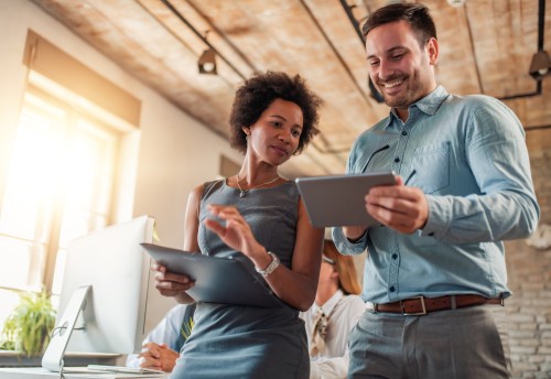 two business advisors in office looking at tablet