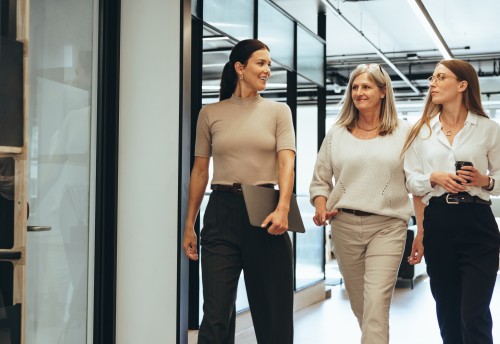 three female accountants walking down hallway chatting